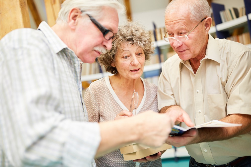 Senior adults reading together in a library