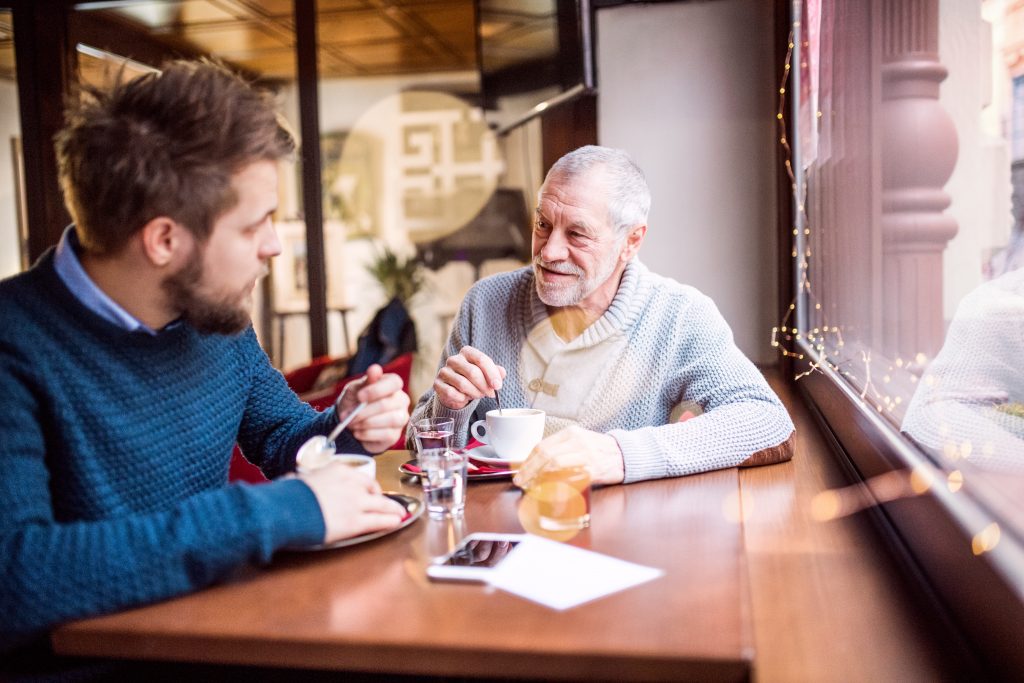 Senior father and his young son in a cafe