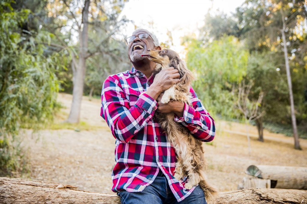 Senior man playing with his dog at the park