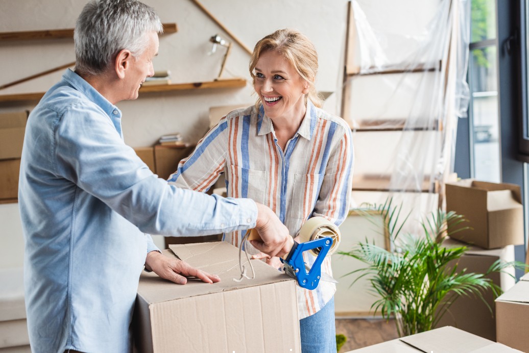 senior couple packing boxes to move into senior living community