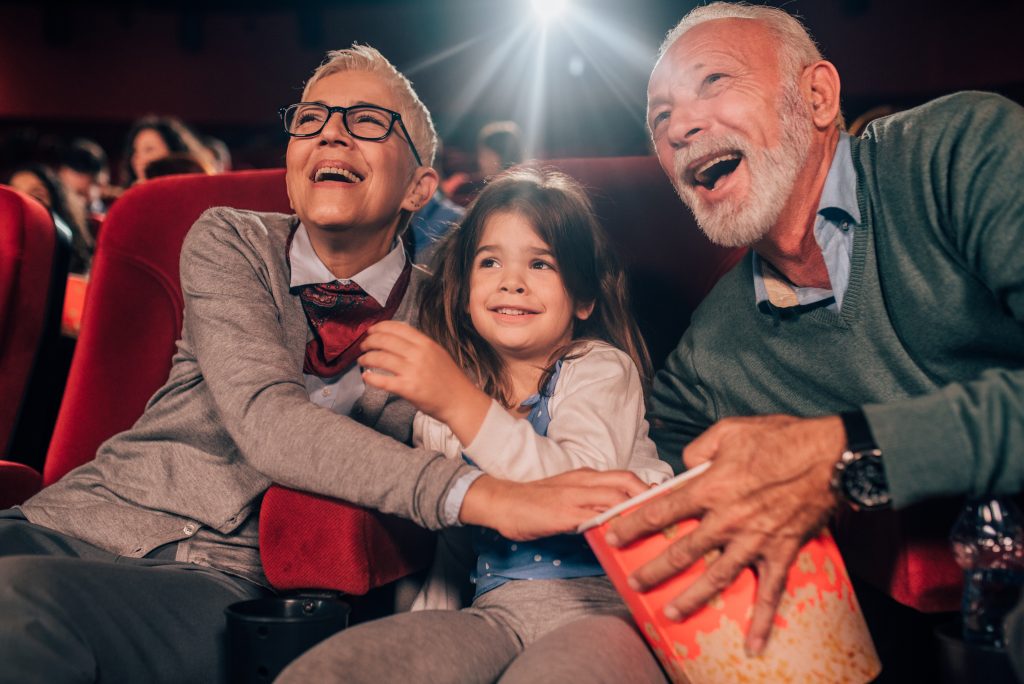Multi-generation family watching a funny movie in the cinema