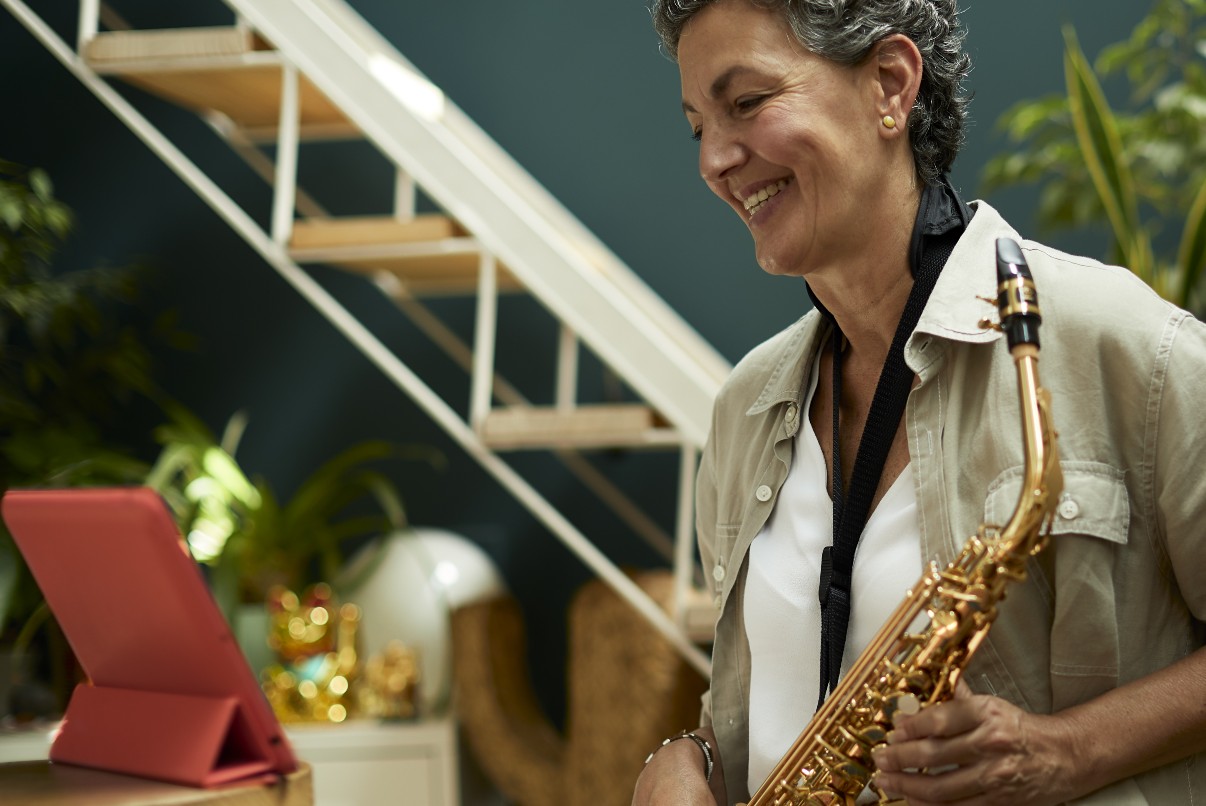 Senior woman learning to play the saxophone online